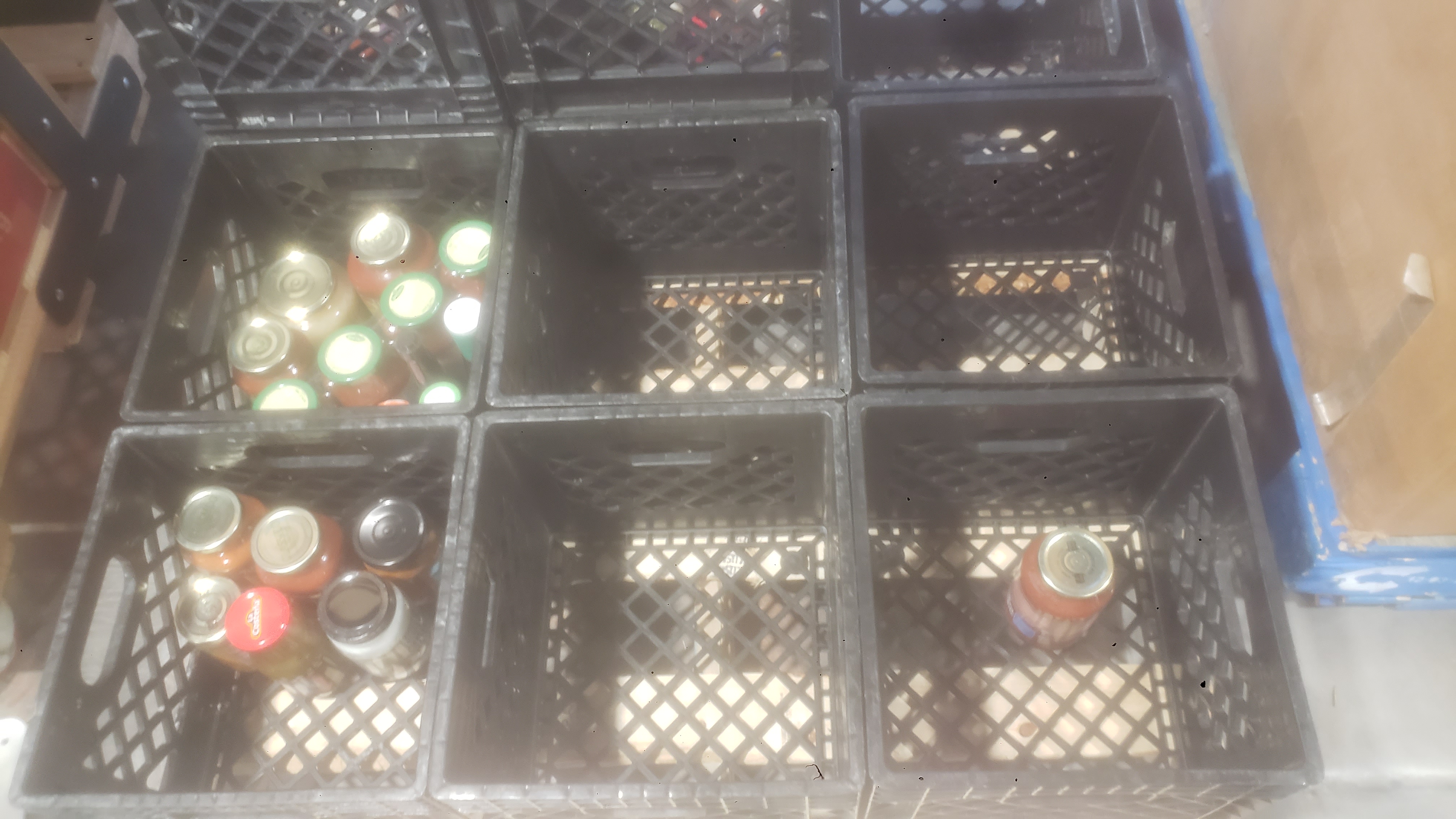 Crates with some filled with glass jars.